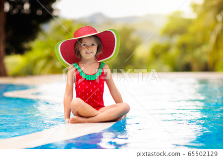 Child with hat in swimming pool. Tropical vacation Child with hat in swimming pool. Tropical vacation 65502129