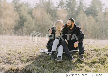 Beautiful couple spend time in a autumn field 65502268