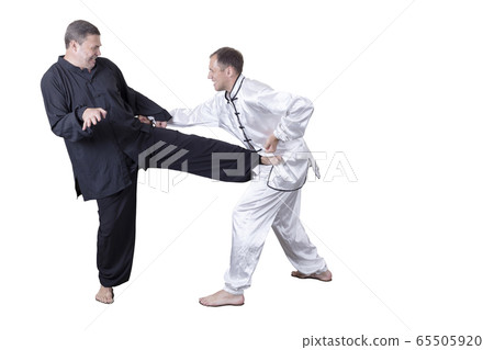 Adult athlete performs formal goju-ryu exercises. 65505920
