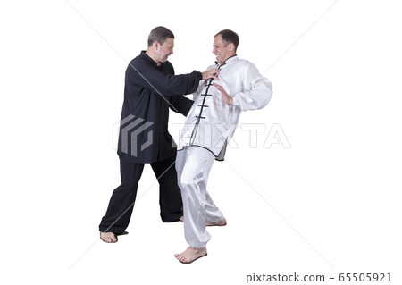 Adult athlete performs formal goju-ryu exercises. 65505921