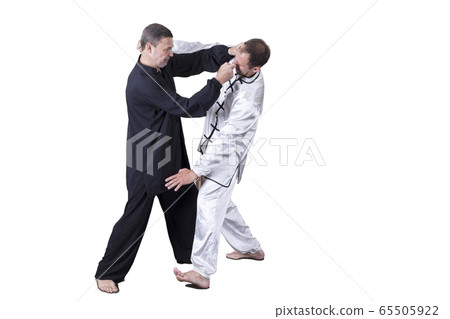 Adult athlete performs formal goju-ryu exercises. 65505922