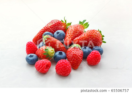 small fruits raspberries strawberries and blueberries close-up on a light background small fruits raspberries strawberries and blueberries close-up on a light background 65506757