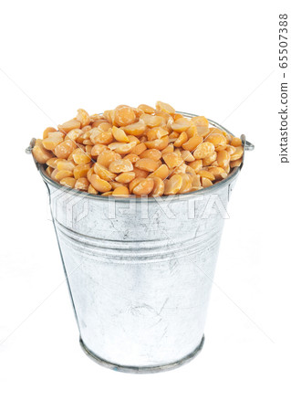 Full bucket of dry peas grains on a white Full bucket of dry peas grains on a white 65507388