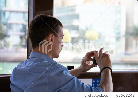 Tourist with a camera on a pleasure boat. Tourist with a camera on a pleasure boat. 65508248