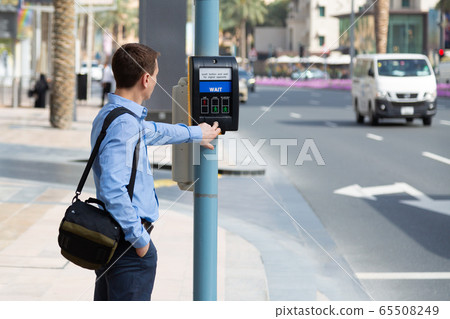 A man at a crosswalk with electronic regulation. A man at a crosswalk with electronic regulation. 65508249