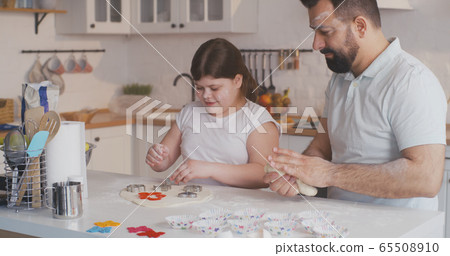 Father and daughter preparing cookies together Father and daughter preparing cookies together 65508910