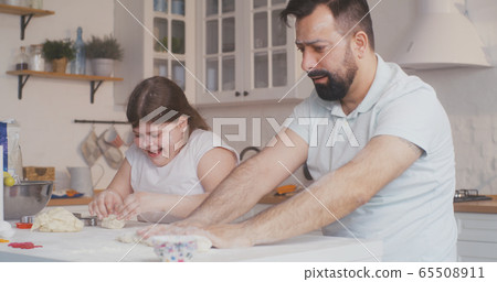 Father and daughter preparing cookies together 65508911