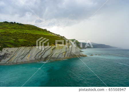 Green hillsides and turquoise water on the coast of Algorri, near Zumaia 65508947