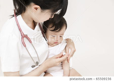 A nurse holding a baby and measuring the temperature with love A nurse holding a baby and measuring the temperature with love 65509156