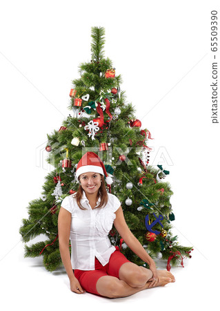 Beautiful smiling woman in Santa cap, sitting near 65509390