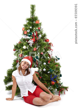 Beautiful smiling woman in Santa cap next to the 65509391