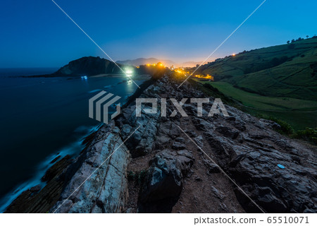 Night view of the cliff with low tide and the light of the full moon in Zumaia Night view of the cliff with low tide and the light of the full moon in Zumaia 65510071