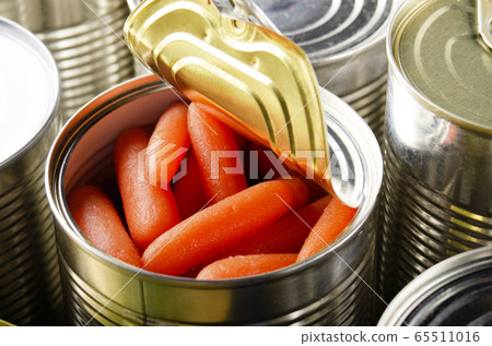 Canned baby carrots in just opened tin can. Canned baby carrots in just opened tin can. 65511016
