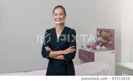 Cosmetology cabinet. Beautician stands in mask and 65511610