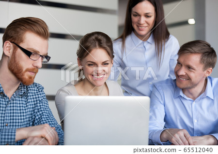 Happy smiling office employees team having fun looking at laptop 65512040