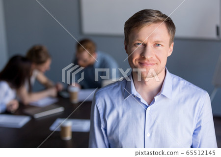 Portrait of smiling successful company ceo with team at backgrou 65512145