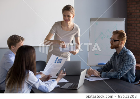 Smiling female ceo giving team financial report with work result Smiling female ceo giving team financial report with work result 65512208