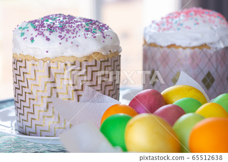 Two Easter cakes and colorful eggs closeup 65512638