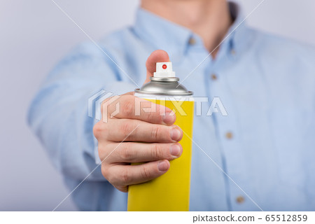 Yellow spray bottle in male hand. Close up. Front Yellow spray bottle in male hand. Close up. Front 65512859