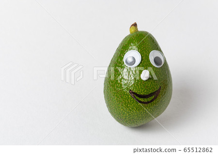 Fun avocado with Googly eyes and smile on white 65512862