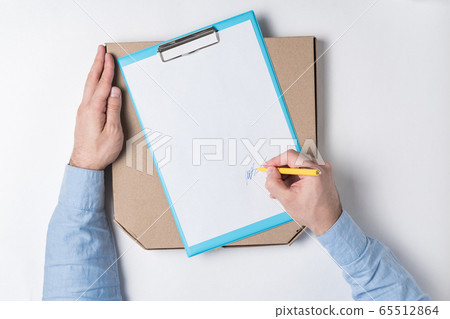 Pizza box and male hand puts a signature on the Pizza box and male hand puts a signature on the 65512864