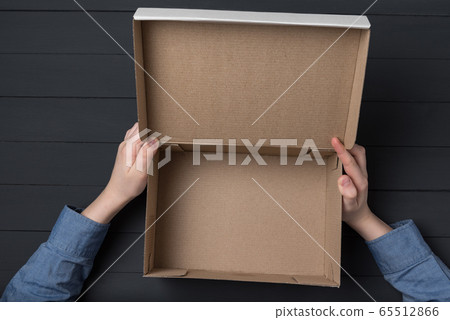 Children's hands holding an open cardboard box. 65512866