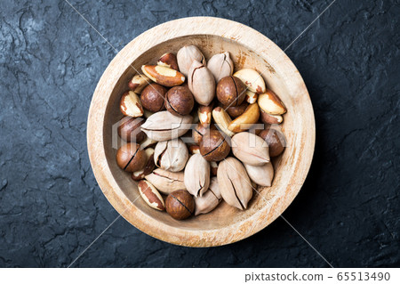 Dried mixed nuts in wooden bowl closeup 65513490