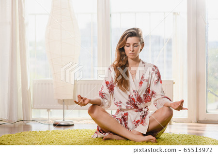 Charming woman at lotus pose at home Charming woman at lotus pose at home 65513972