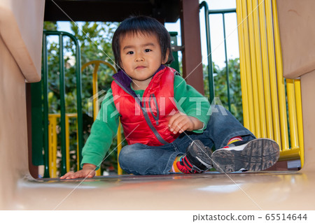 3 year old boy playing on a slide 3 year old boy playing on a slide 65514644