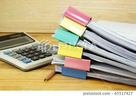 file folder and Stack of business report paper file with ..Calculator on the table in a work office, concept document in work office file folder and Stack of business report paper file with ..Calculator on the table in a work office, concept document in work office 65517427