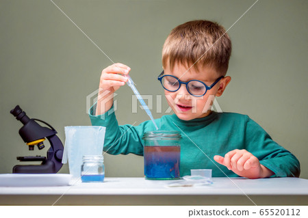 Small boy studies chemistry. Testing tubes with 65520112