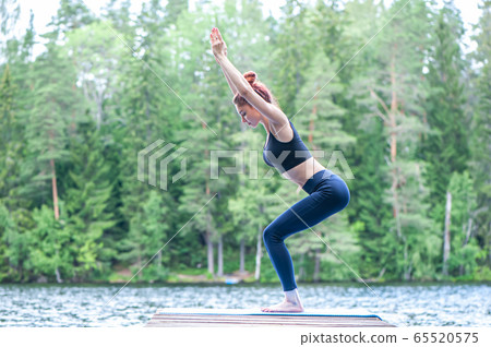 Young yogi girl practicing yoga, standing in Young yogi girl practicing yoga, standing in 65520575