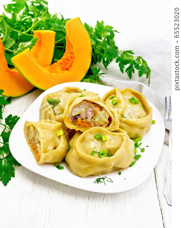 Manty with meat and pumpkin in plate on white 65523020