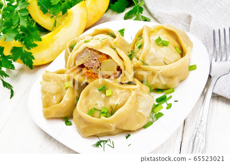 Manty with meat and pumpkin in plate on wooden 65523021