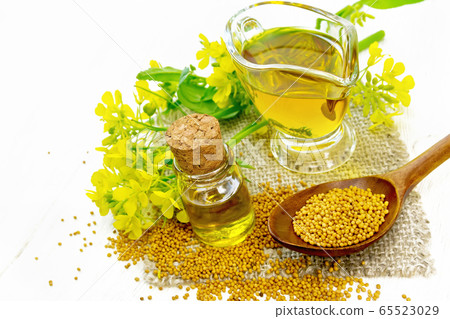 Oil mustard in jars and gravy boat on light board 65523029