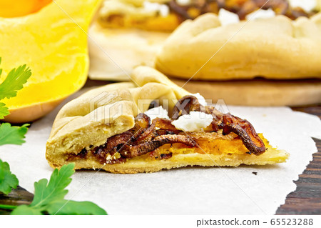 Pie with pumpkin and fried onions on dark board 65523288