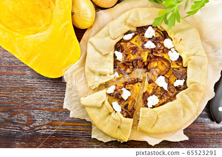 Pie with pumpkin and onions on dark board top Pie with pumpkin and onions on dark board top 65523291