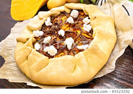 Pie with pumpkin and onions on parchment Pie with pumpkin and onions on parchment 65523292
