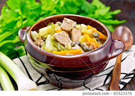 Soup Eintopf in clay bowl on towel 65523378