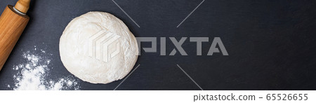 Dough, rolling pin and flour on a black background 65526655