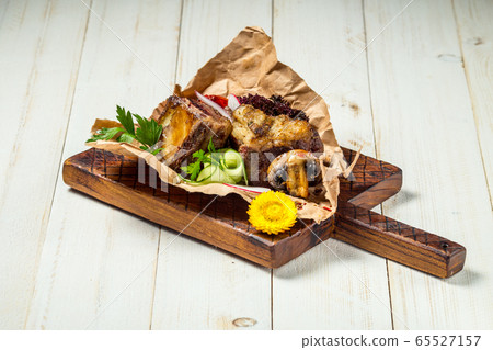 Roasted grilled beef meat pieces on wooden board 65527157