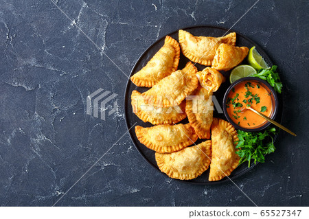 Buffalo Chicken Empanadas on a black plate Buffalo Chicken Empanadas on a black plate 65527347