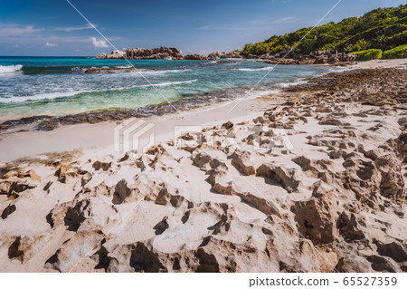 Rough sharp old coral coastline on remote beach with granite rocks, Grand L Anse, La Digue, Seychelles Rough sharp old coral coastline on remote beach with granite rocks, Grand L Anse, La Digue, Seychelles 65527359