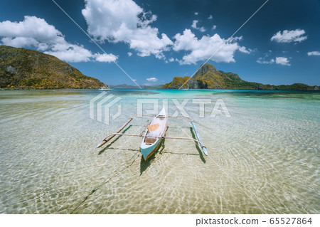 El Nido bay. Palawan island, Philippines. Lonely filippino fishing boat in shallow water lagoon at noon. Travel exotic 65527864