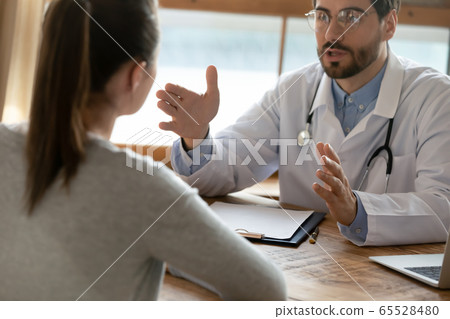 Caucasian male doctor consult female patient at meeting 65528480