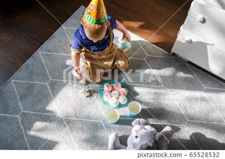 Little child is playing with birthday cakes Little child is playing with birthday cakes 65528532