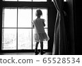 Child is standing and looking out the window. Stay at home and quarantine concept. Sadness of the toddler. 65528534