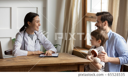 Smiling young dad with son consult at female pediatrician Smiling young dad with son consult at female pediatrician 65528535
