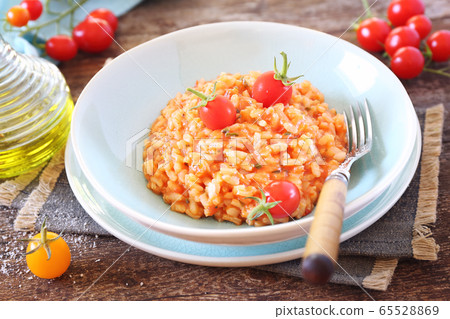 Italian cuisine. Plate of tomato risotto, olive oil and cherry tomatoes 65528869