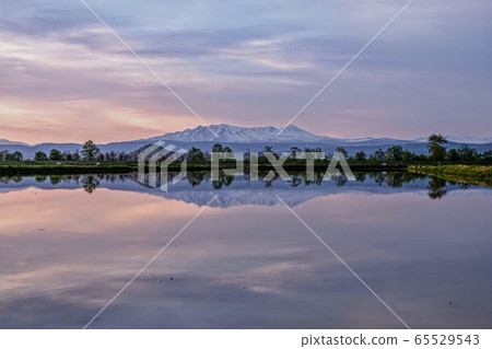 Daisetsuzan in spring and the sunrise sky reflected in the rice fields before rice planting Daisetsuzan in spring and the sunrise sky reflected in the rice fields before rice planting 65529543